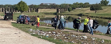 Group cleaning up near river banks after 2022 flooding.