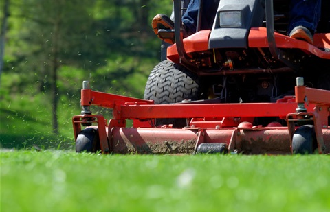 up close view of a mower mowing grass