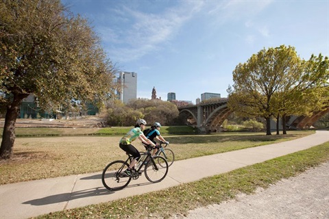 two cyclists pass by along the Trinity Trail