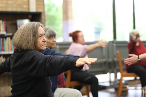 Participants practice chair yoga at a free session at the Riverside Library in 2026.