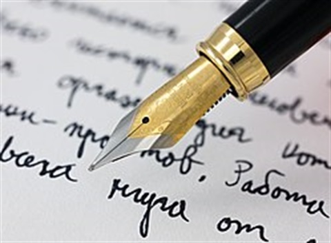 a fountain pen pictured with a page of cursive handwriting