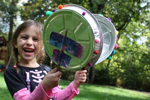 a girl making music with pie tins