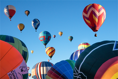 An image of hot air ballons across a blue sky