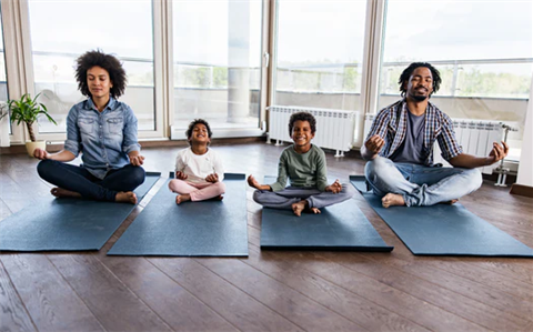 mom, son, daughter and dad practicing yoga moves