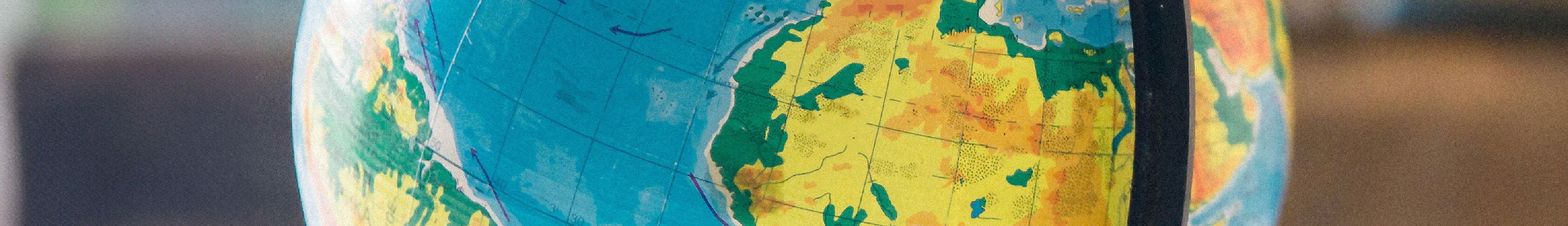 A photo of a globe of the world. The globe is situated on the continent of Africa.