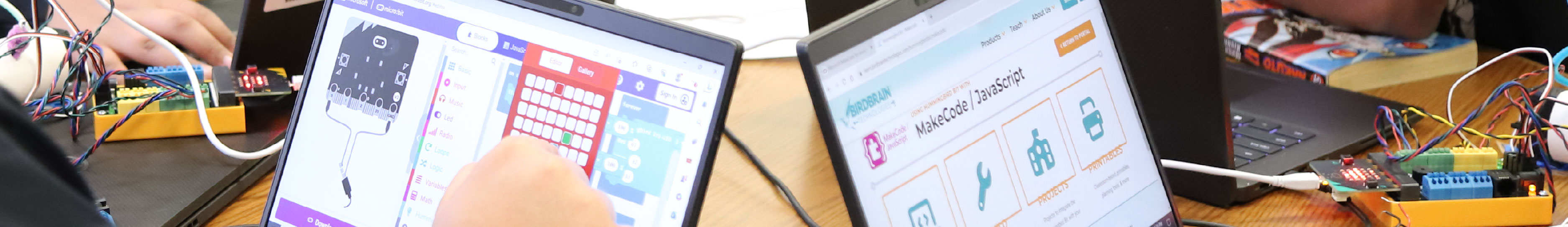 Teens working on laptops engaging in coding activities.