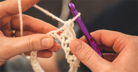 hands knitting white yarn