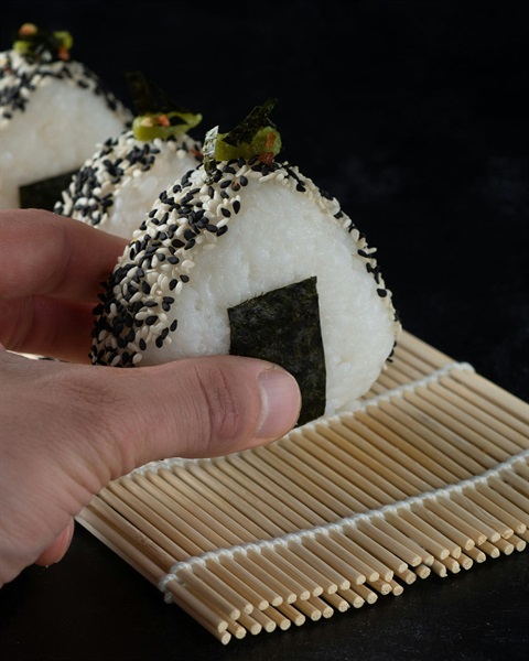 Japanese Onigiri being carefully picked up by a hand