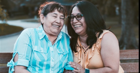 senior citizen sitting with her daughter on a bench outside