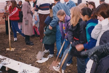 Community members participate in the groundbreaking by digging up dirt.