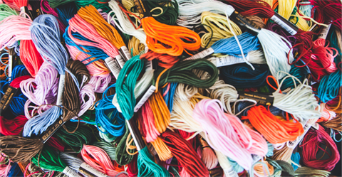 hands knitting different color threads 