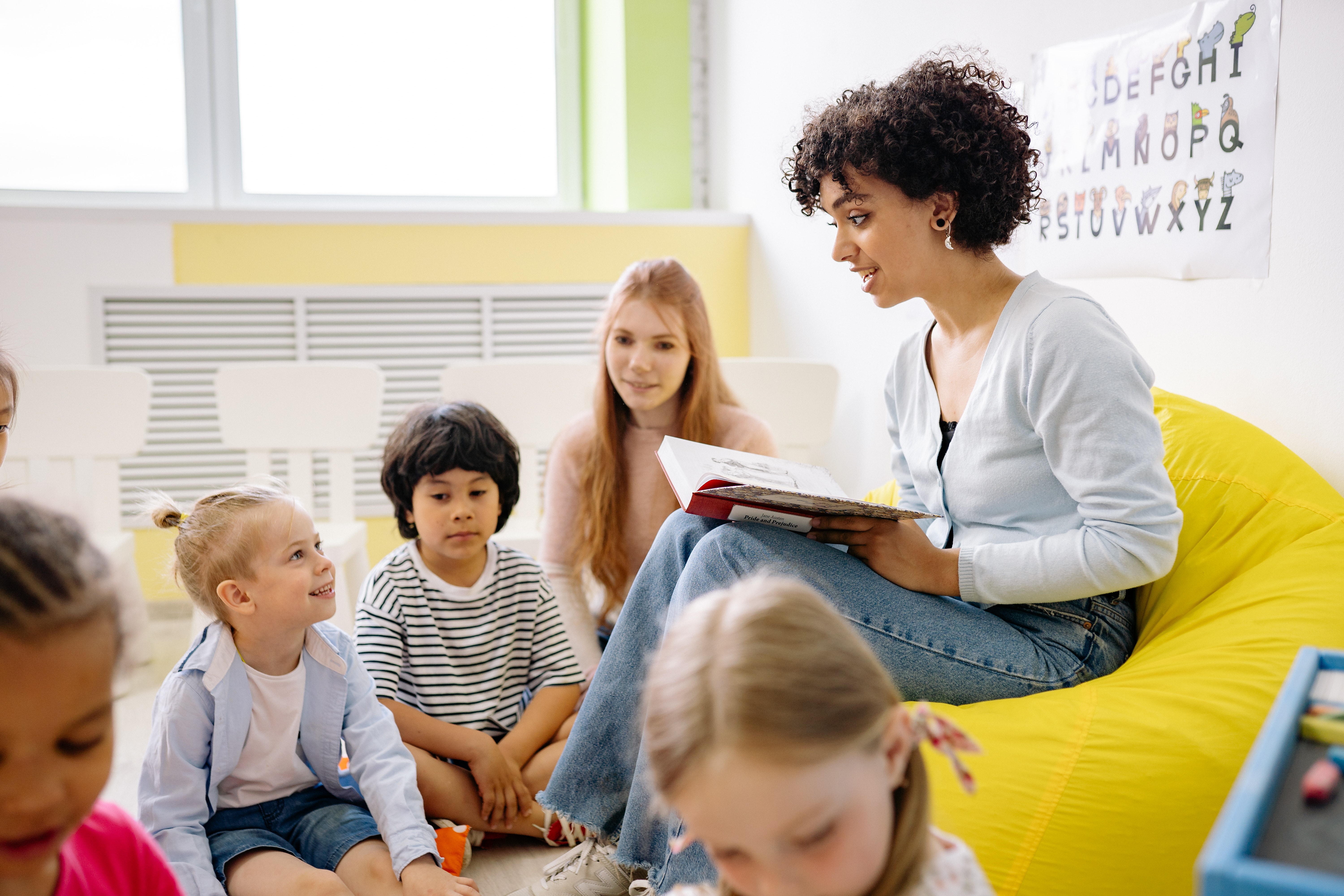 seated-children-with-teacher-reading-book