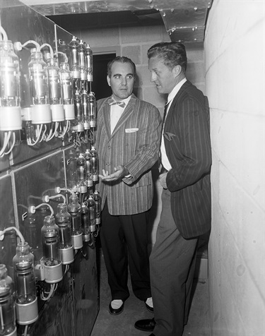 St. John Terrell, right, who produced the first musical comedy-in-the-round, inspects the latest in stage lighting equipment. Melvin Dacus points out the various bells and whistles. (Photo: Fort Worth Star-Telegram Collection, University of Texas at Arlington Libraries)