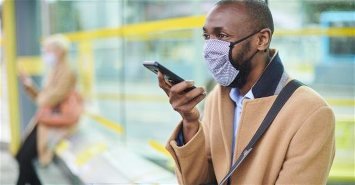 a man wearing a mask while talking into a phone