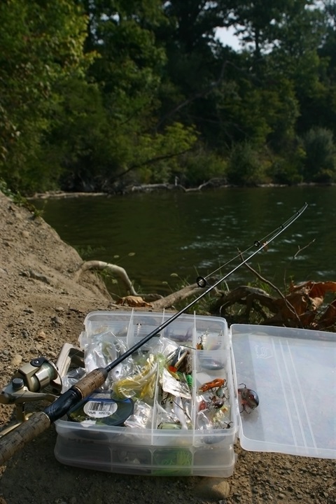 Fishing pole and tacklebox by a lake