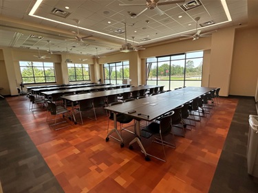 Multipurpose room with tables chairs and windows