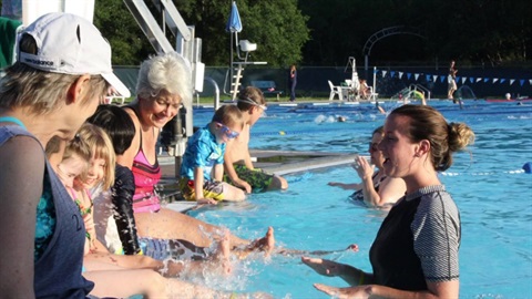 Children and adults sitting on the pool edge