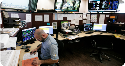 Employee at a desk blow monitors showing water data