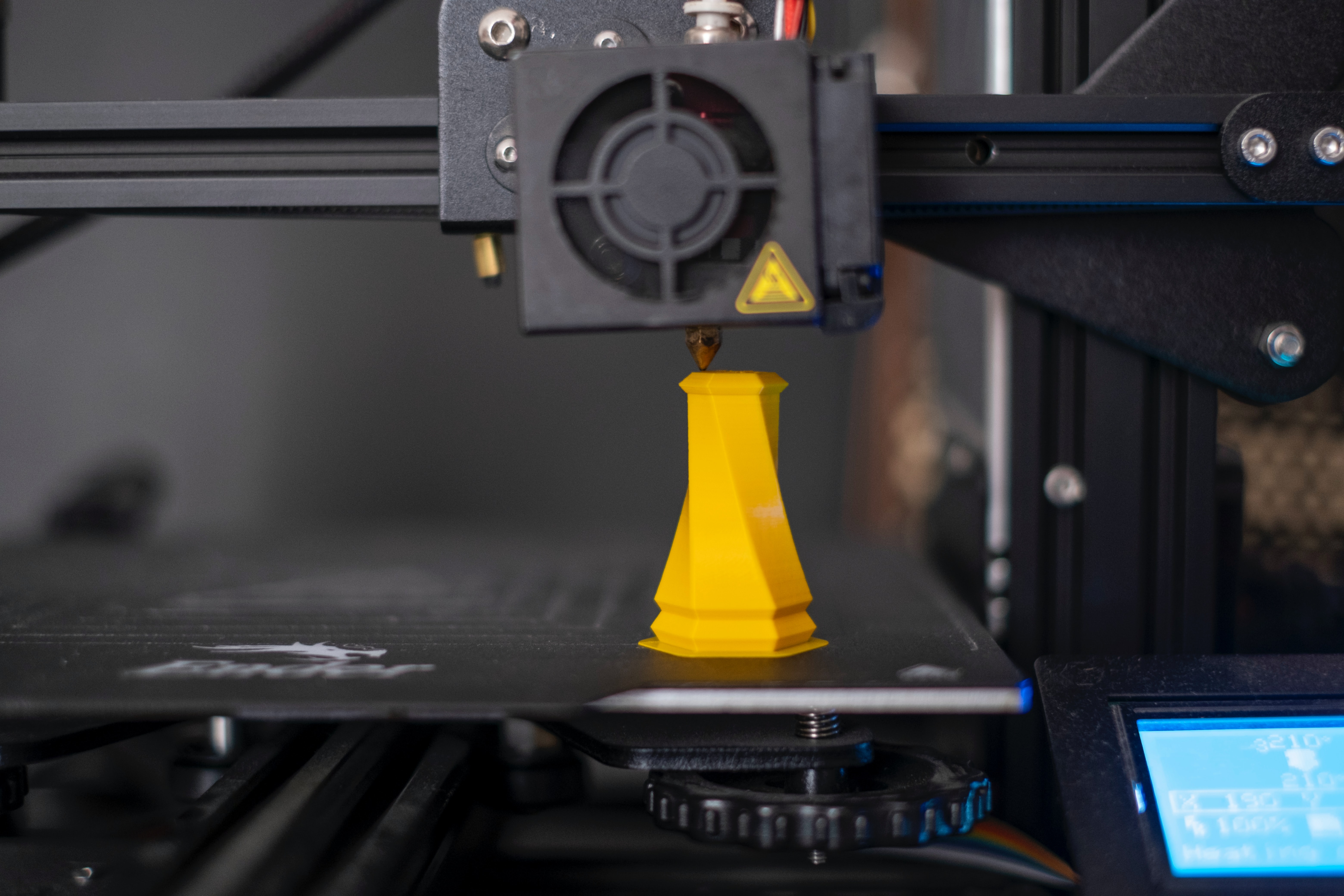 Image of a 3D printer printing a yellow geometric object
