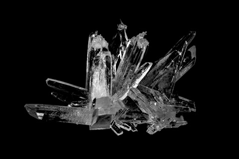 image of a clear, colorless crystal with a dark background