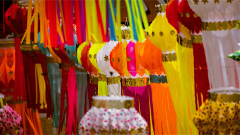 Colorful Diwali lanterns hang in a marketplace.
