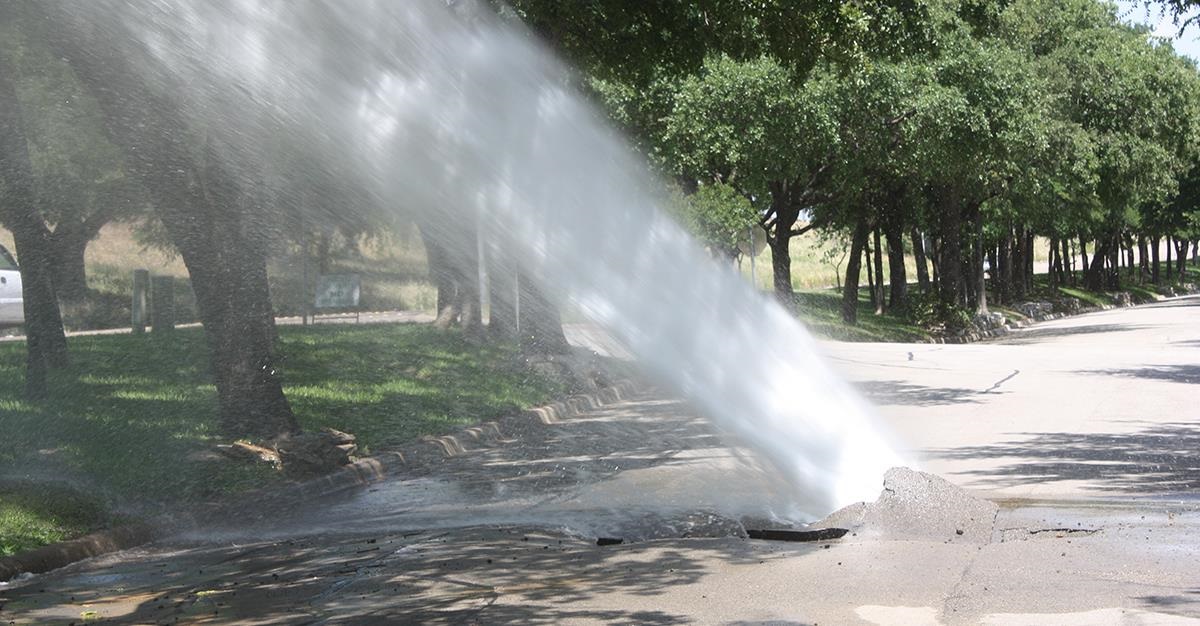 an airborne main break that has busted through the street